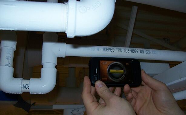 This pipe is pitched UP, 1.8 degrees according to my handy-dandy smart phone level.  Of course it is…it had to get over the bar joist in the right of the picture!