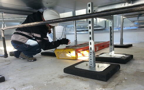 A commissioning engineer performing construction checkout on ERV duct work
