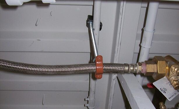 This pipe clamp puts the weight on the flexible hose and its coupling, neither of which are rated to support weight.